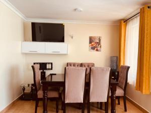 a dining room with a table and a tv at Crystal Luxury Palace in Nairobi