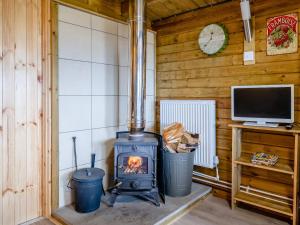 a woodburning stove in a room with a tv at Starling Lodge - Uk31071 in Westward
