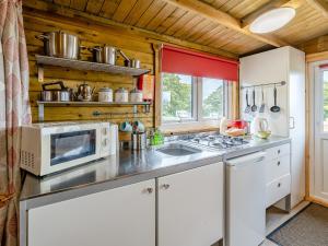 a kitchen with a microwave and a stove at Starling Lodge - Uk31071 in Westward