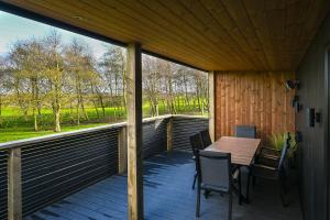 a wooden deck with a table and chairs on it at Staining Luxury Lodges in Poulton le Fylde