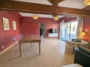 a dining room with red walls and a table and chairs at Le Clos d Emilie in Saint-Marcel