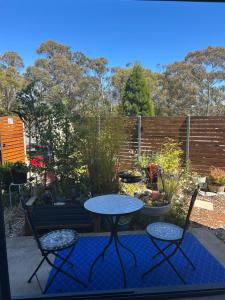 a patio with a table and two chairs and a bench at Relaxing Hobart Retreat, Stylish 2-Bed Apartment in Sandy Bay