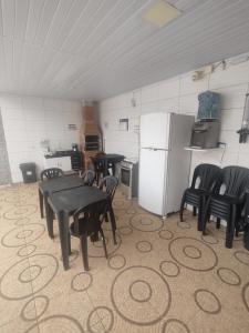 a kitchen with a table and chairs and a refrigerator at Chalé Arizona in São Roque