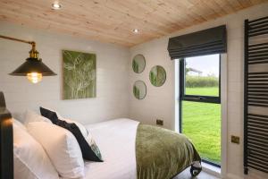 a small bedroom with a bed and a window at Staining Luxury Lodges in Poulton le Fylde