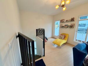 a living room with a staircase and a yellow chair at Nogueira Home in Passa Quatro