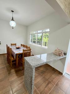 a kitchen and dining room with a table and chairs at Nogueira Home in Passa Quatro