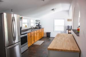 a kitchen with a stainless steel refrigerator and wooden cabinets at Westport Whitehouse in Westport