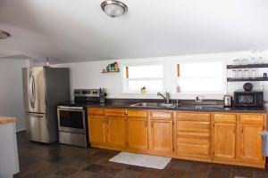 a kitchen with wooden cabinets and a stainless steel refrigerator at Westport Whitehouse in Westport +7 photos