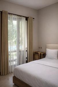 a bedroom with a bed and a large window at GGuesthouse in Kuta Lombok