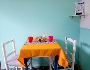 a table with a yellow table cloth and red cups on it at Apart Tunuyan B&B in Tunuyán +1 photo