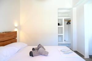 a bedroom with a white bed with a tie on it at Alkyoni Celeste Kythnos in Kithnos