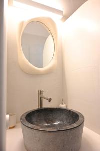 a bathroom with a stone sink and a mirror at Alkyoni Celeste Kythnos in Kithnos +12 photos