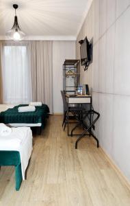 a room with two beds and a desk and a television at Karczma Kujawska in Inowrocław