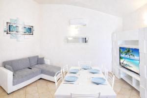 a living room with a white table and a couch at International House San Teodoro in San Teodoro