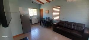 a living room with a couch and a kitchen at Quillon cabañas in Quillón