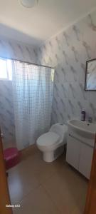 a white bathroom with a toilet and a sink at Quillon cabañas in Quillón +11 photos