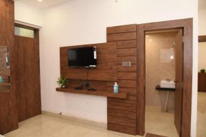 a living room with a tv on a wall at Hotel New M I Plaza in Gaya