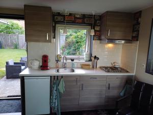 a small kitchen with a sink and a window at Sunrise in Hollum