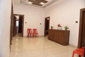 a waiting room with two red chairs and a desk at Hotel New M I Plaza in Gaya