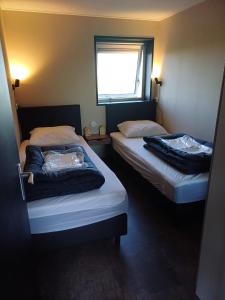 two twin beds in a room with a window at Sunrise in Hollum
