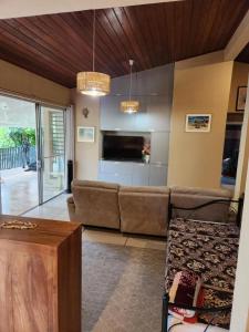 a living room with a couch and a tv at Wendy Location in Papeete