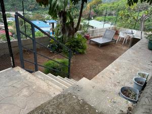 a set of stairs with a bench and a tree at Wendy Location in Papeete