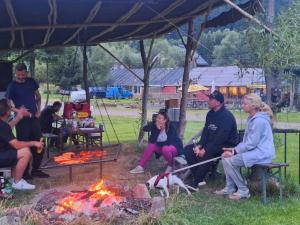 a group of people sitting around a fire at Domki bungalowe nr 8 in Stosrow