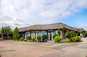 a building with a thatched roof and a bench at Karczma Kujawska in Inowrocław
