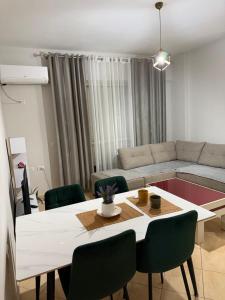 a living room with a table and green chairs at Leo apartaments with sea view in Durrës +13 photos
