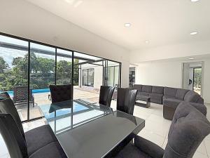 a dining room with a glass table and chairs at Villa adhara in Quimbaya