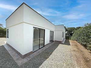 a white building with large windows on the side of it at Villa adhara in Quimbaya