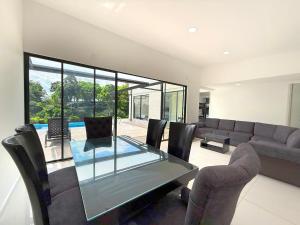 a living room with a glass table and chairs at Villa adhara in Quimbaya
