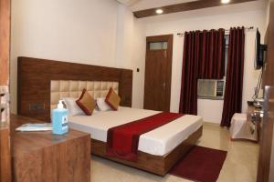 a bedroom with a large bed and a table with a bottle of water at Hotel New M I Plaza in Gaya +19 photos