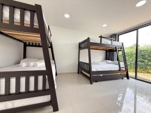 two bunk beds in a room with a window at Villa adhara in Quimbaya +31 photos