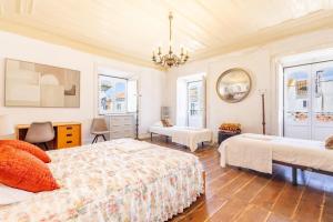 a bedroom with two beds and a chandelier at Salvaterra de Magos in Salvaterra de Magos