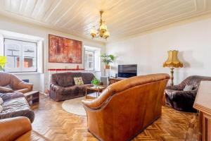 a living room with leather furniture and a ceiling at Salvaterra de Magos in Salvaterra de Magos