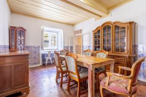 a dining room with a wooden table and chairs at Salvaterra de Magos in Salvaterra de Magos