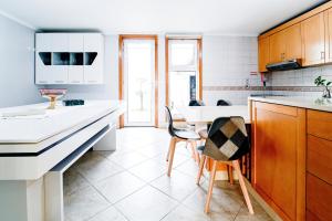 a kitchen with white countertops and wooden cabinets at Casa Tomé de Sousa in Rates