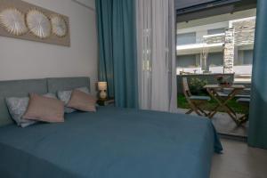 a bedroom with a blue bed and a balcony at Studio Apartments Itaka in Nikiti +21 photos