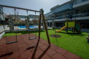 a playground with a slide and a swing at Studio Apartments Itaka in Nikiti