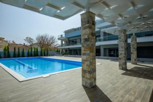 a swimming pool in front of a building at Studio Apartments Itaka in Nikiti