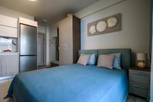 a bedroom with a blue bed and a refrigerator at Studio Apartments Itaka in Nikiti