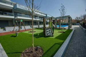 a playground with two trees and a swing at Studio Apartments Itaka in Nikiti