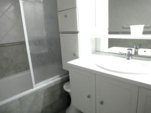 uma casa de banho com um lavatório, um WC e um espelho. em Enticing Apartment in M ribel with Balcony em Méribel