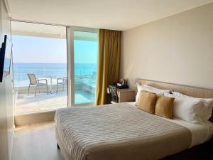 a bedroom with a bed and a view of the ocean at Hôtel La Plage in Sainte-Maxime