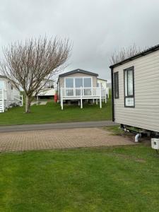a mobile home with a bench and a house at Paws a while in Mainsriddle