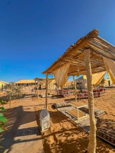 a wooden pavilion in the middle of the desert at Merzouga heritage camp in Merzouga
