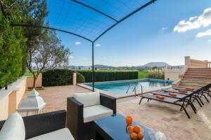 a patio with a pool and a table and chairs at Sort Nova in Montuiri