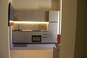 a kitchen with white appliances and a brick wall at Appartamento PALE 2 posti letto in Pale +5 photos