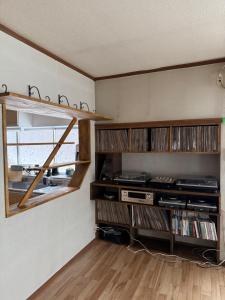 a room with wooden shelves and a window with dvds at 自然体験と石窯のある古民家民泊アジールAsyl in Hirosaki
